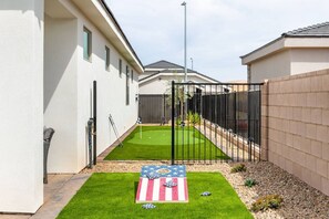 A residential property with a small lawn, a flag decoration, and a gated area.