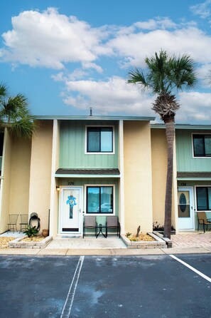 A two-story motel with a parking lot in front. - Cozy 2-bedroom condo with AC in welcoming Panama City Beach (Panama City Beach)