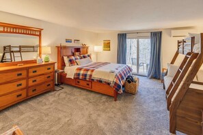 A bedroom with a wooden bed, a dresser, a mirror, and a window with curtains. - Waterville Estates Condo- Hot Tub- Pools- Ski Mtn (Campton)