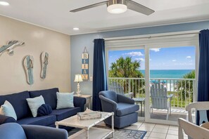 A room with a sofa, armchairs, a coffee table, a lamp, and a view of the beach through a sliding glass door. - The Summit 308 - Best of PCB with Beach Service (Panama City Beach)