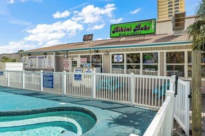 A pool area with a sign for Bikini Bob's Bar & Grill, a menu board, and a no diving sign. - The Summit 225 - Ocean Views & Beach Vibes (Panama City Beach)
