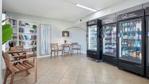 A modern interior with a seating area, a bookshelf, and two 24-hour vending machines. - The Summit 225 - Ocean Views & Beach Vibes (Panama City Beach)