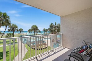 A balcony with a view of a pool, palm trees, and a beach. - The Summit 225 - Ocean Views & Beach Vibes (Panama City Beach)