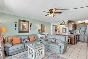 A living room with a grey sectional sofa, a white coffee table, and a ceiling fan. - The Summit 225 - Ocean Views & Beach Vibes (Panama City Beach)