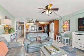 A living room with a sofa, coffee table, and a ceiling fan. - The Summit 225 - Ocean Views & Beach Vibes (Panama City Beach)