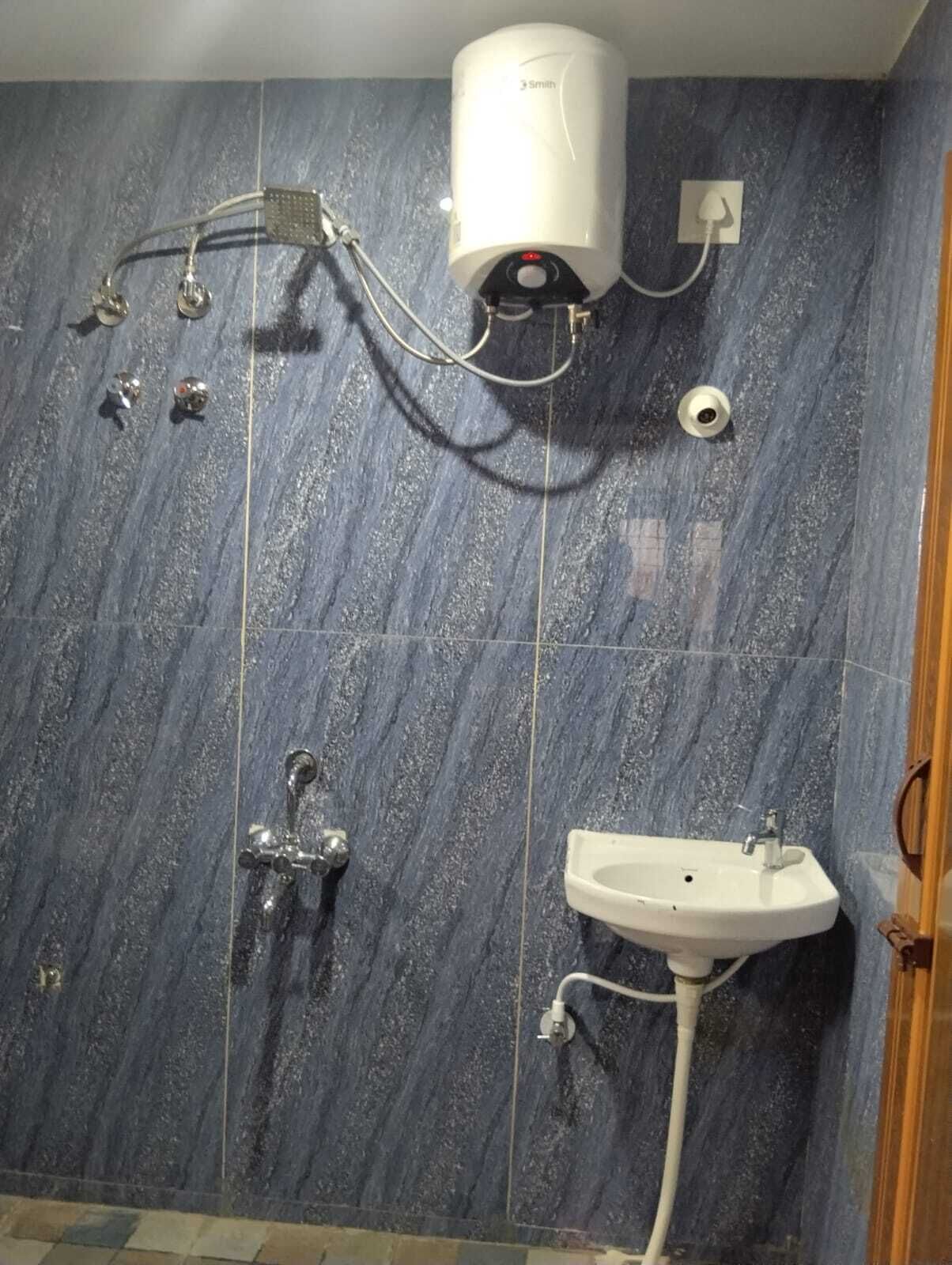 A bathroom with a shower, a sink, and a water heater.