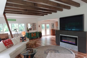 A living room with a fireplace, a sofa, a coffee table, and a television.