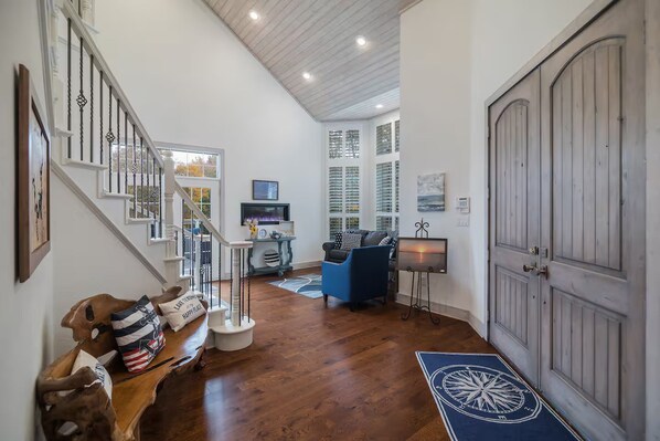 A spacious living area with a staircase, a blue sofa, and a fireplace.