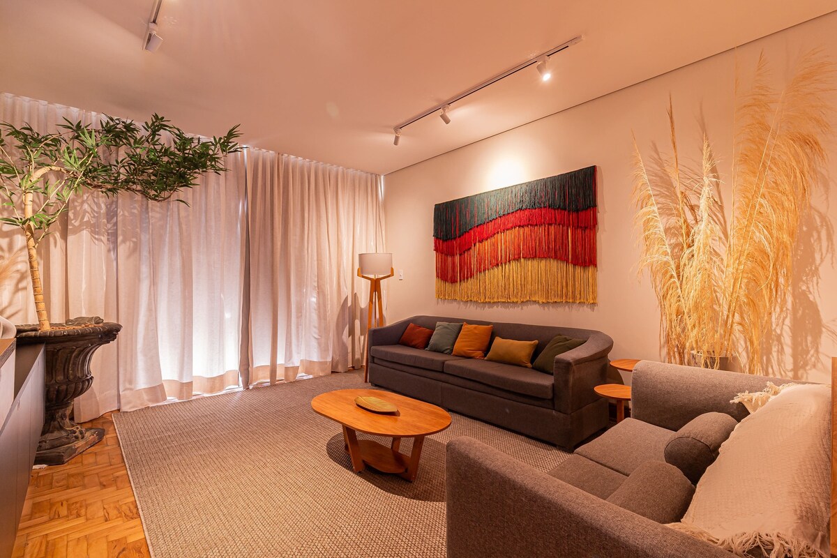 Ein modernes Wohnzimmer mit einer Couch, einem Couchtisch und einem großen, abstrakten Gemälde.