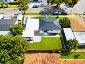 Ein Wohnhaus mit geneigtem Dach, einem gepflegten Rasen und einem eingezäunten Garten.