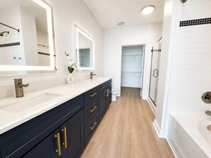 A modern bathroom with a double sink vanity, a shower area, and a toilet. - Stylish 2BR Charlotte Stay | Pool, Gym & BBQ (Charlotte)