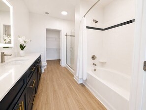 Uma casa de banho moderna com chuveiro, sanita e lavatório.
