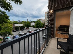 Ein Balkon mit Blick auf einen Parkplatz und Stadtgebäude.