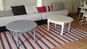 A living room with a sofa, two round tables, and a striped rug. - The Perfect Vacation, 20 Minutes from the Airport in the Marrakech Countryside, Sleeps 12 (Marrakech)