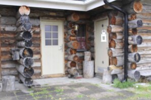 Eine Blockhütte mit Eingangstür und einer kleinen Veranda.