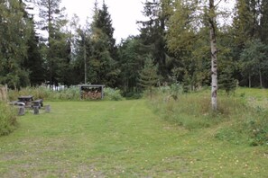 Ein Rasenplatz mit Picknicktisch und kleiner Schutzhütte.
