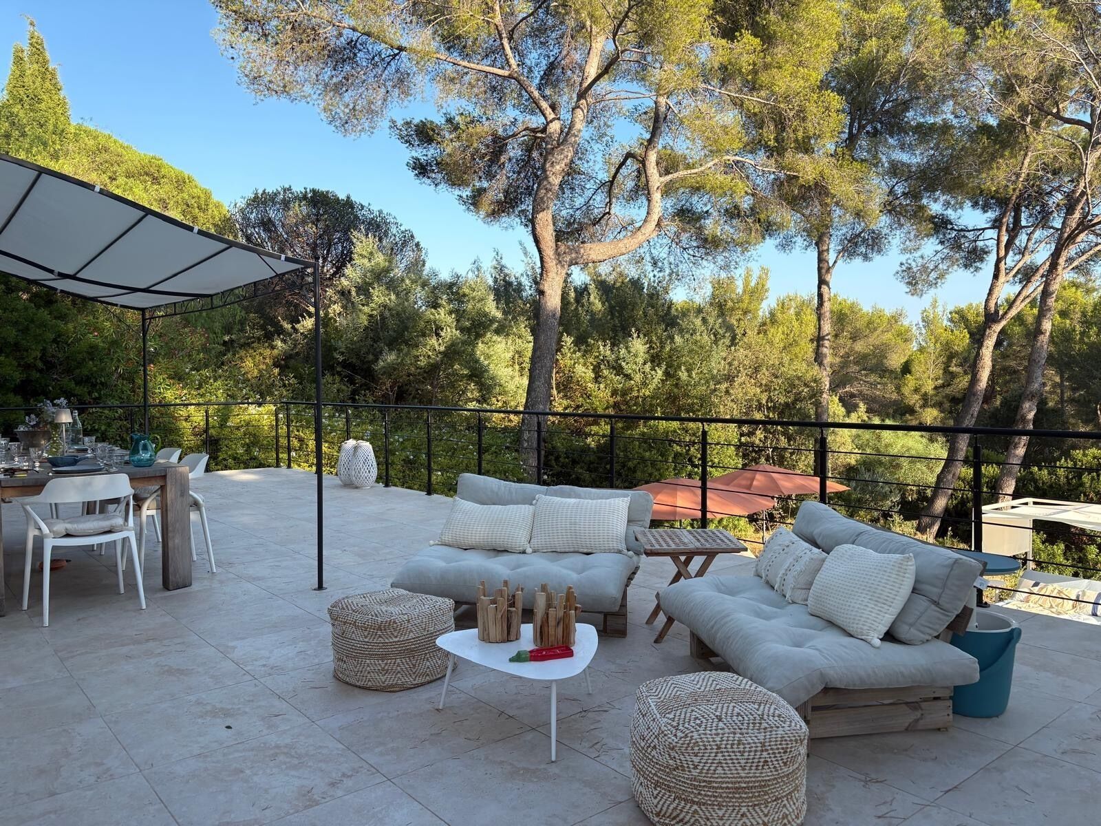 An outdoor patio with a dining set, sofas, and a round table.