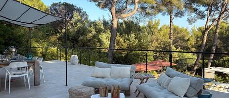 An outdoor patio with a dining set, sofas, and a round table.