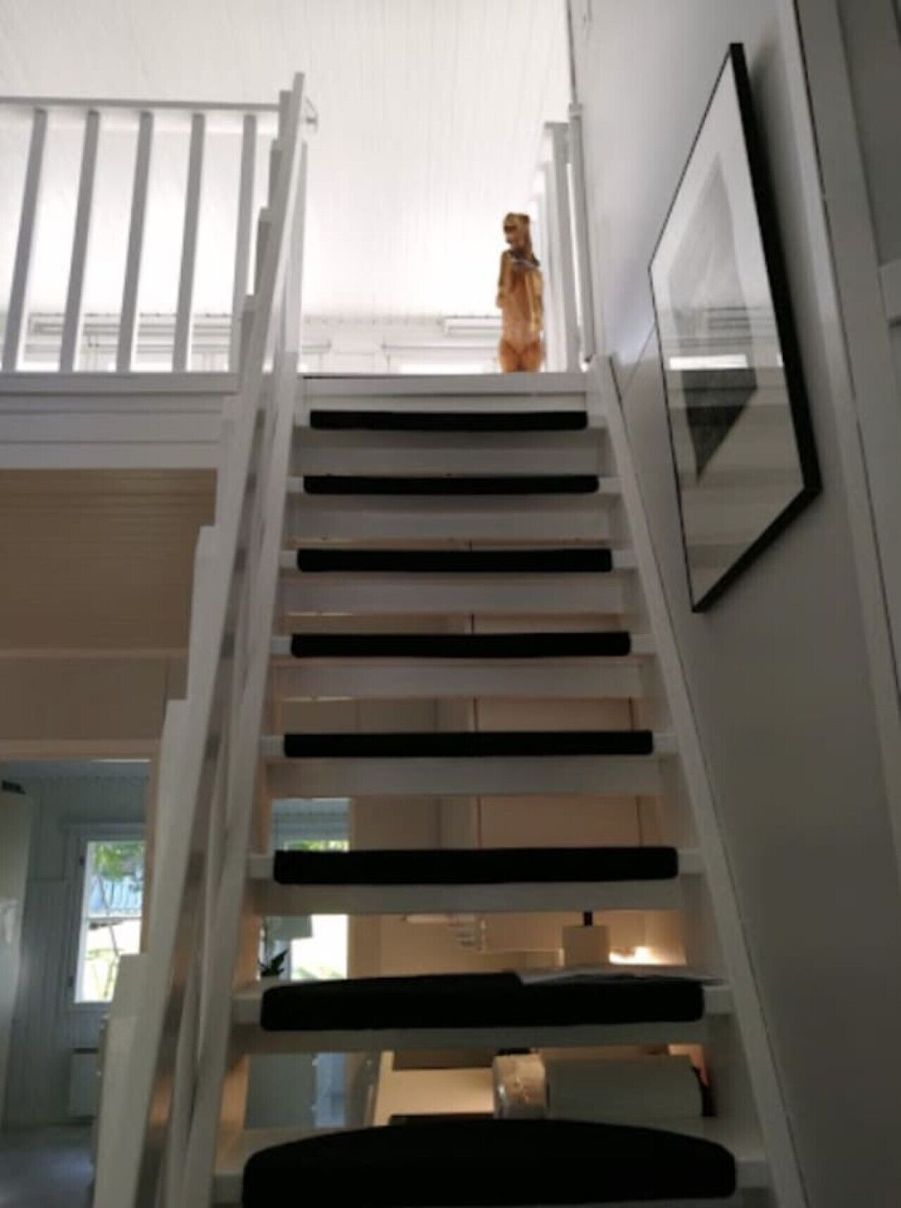A staircase with a handrail and a framed picture on the wall.