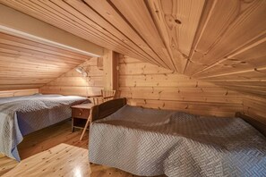 Eine Hütte mit zwei Betten, einem Schreibtisch und einem Stuhl.
