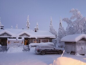 A snow-covered house with a car parked in the driveway. - Maston Uuttu | Ruka Cabin Near Ski Trails & Slopes (Ruka)