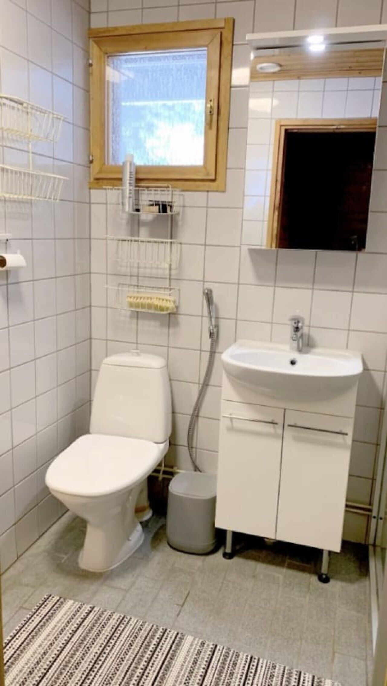 Un baño pequeño con inodoro, lavamanos y ventana.