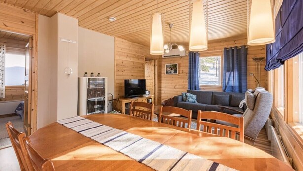 A wooden interior with a dining table, chairs, a sofa, and a television. - Jyrkkälä B | Family-Friendly Apt Near Ski Slopes (Ruka)