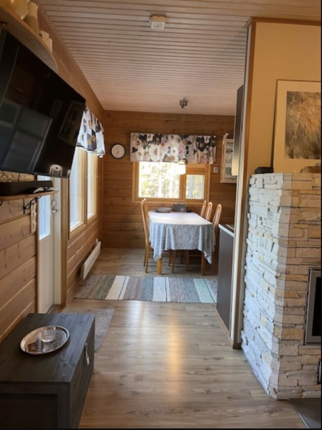 Un interior de madera con comedor, cocina con estufa y chimenea.