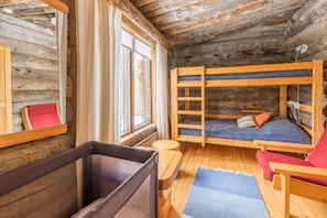 A cabin with bunk beds, a small table, and a chair. - RukanTykky | Charming 3BR Chalet | Near Slopes (Ruka)