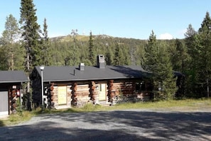 A log cabin with a chimney, surrounded by trees and a clear sky. - RukanTykky | Charming 3BR Chalet | Near Slopes (Ruka)