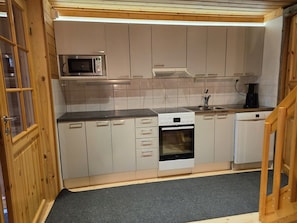 Eine kleine Küche mit Mikrowelle, Backofen und Geschirrspüler.