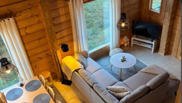 A cozy cabin interior with a sofa, dining table, and a television. - Nietos A | Comfy Cabin in Ruka | Private Sauna (Ruka)