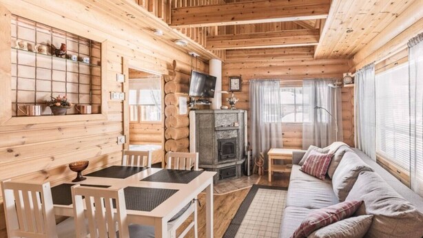 A cozy cabin interior with a wooden interior, a fireplace, a sofa, and a dining area. - Mäntyruka A2 | Cozy 1BR Cabin | Sauna & Fireplace (Ruka)