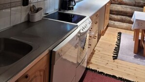Une cuisine avec des meubles de rangement en bois, une cuisinière et une machine à café.