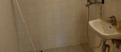 A bathroom with a shower, a sink, and a toilet.
