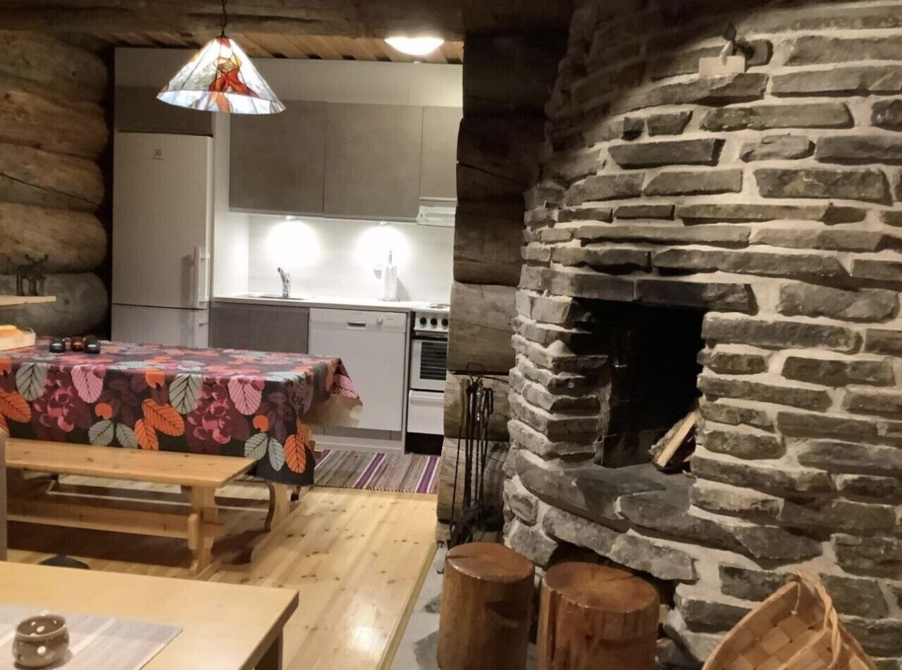 Un intérieur rustique avec une cheminée en pierre, des meubles en bois et un coin cuisine.