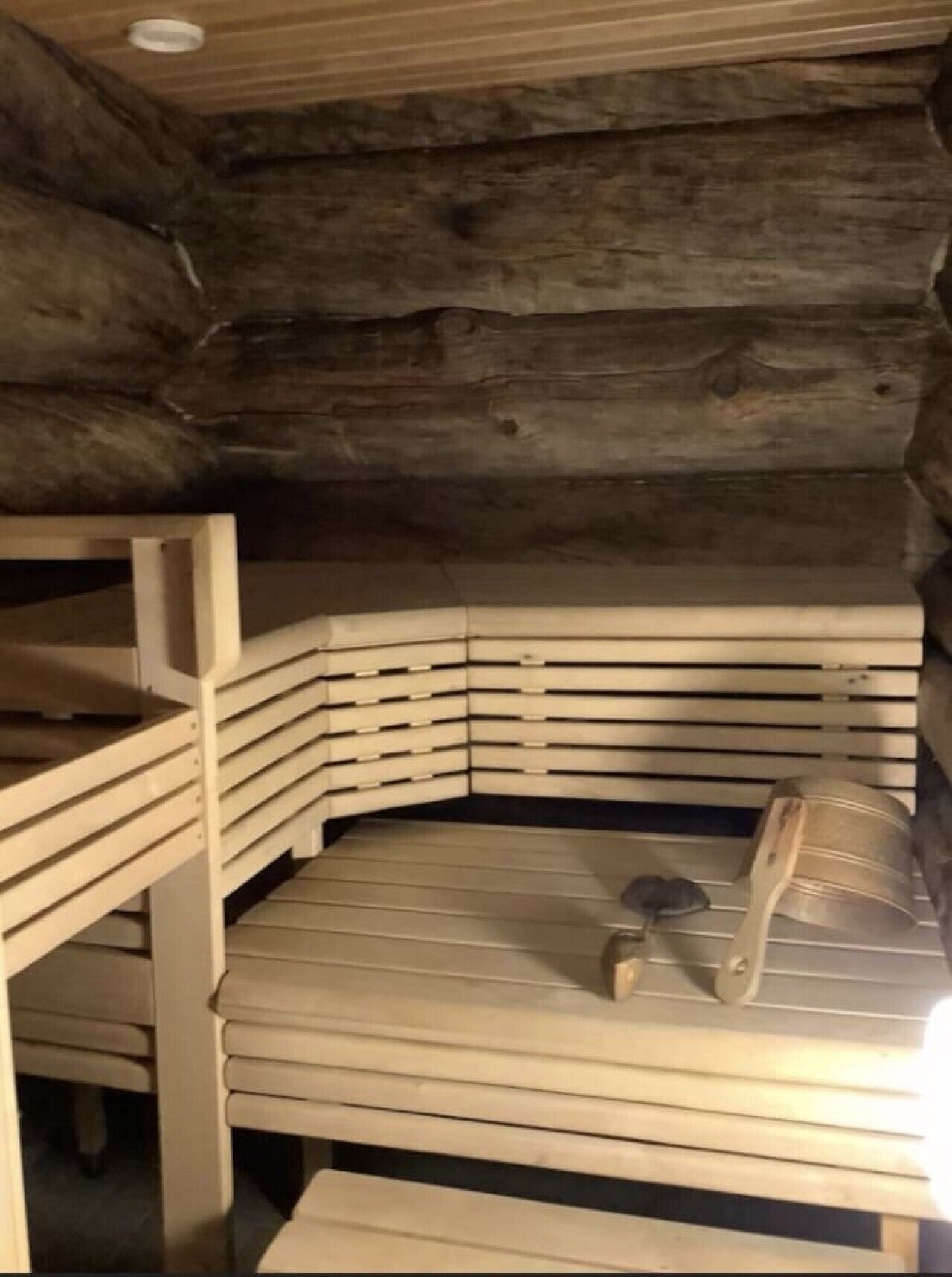 Una sauna de madera con bancos dispuestos en semicírculo.