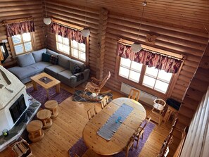A log cabin interior with a living area, dining table, and a fireplace. - Cozy Lakeside Cabin for 12 | Sauna & Lappish Hut (Kuusamo)