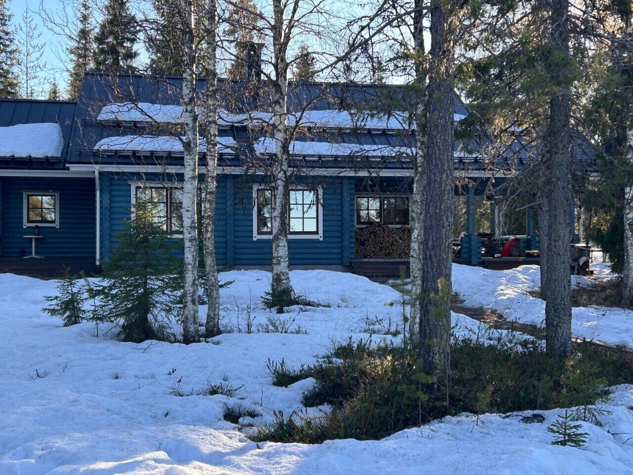 Une cabane dont le toit est recouvert de neige et dont l’extérieur est en bois.