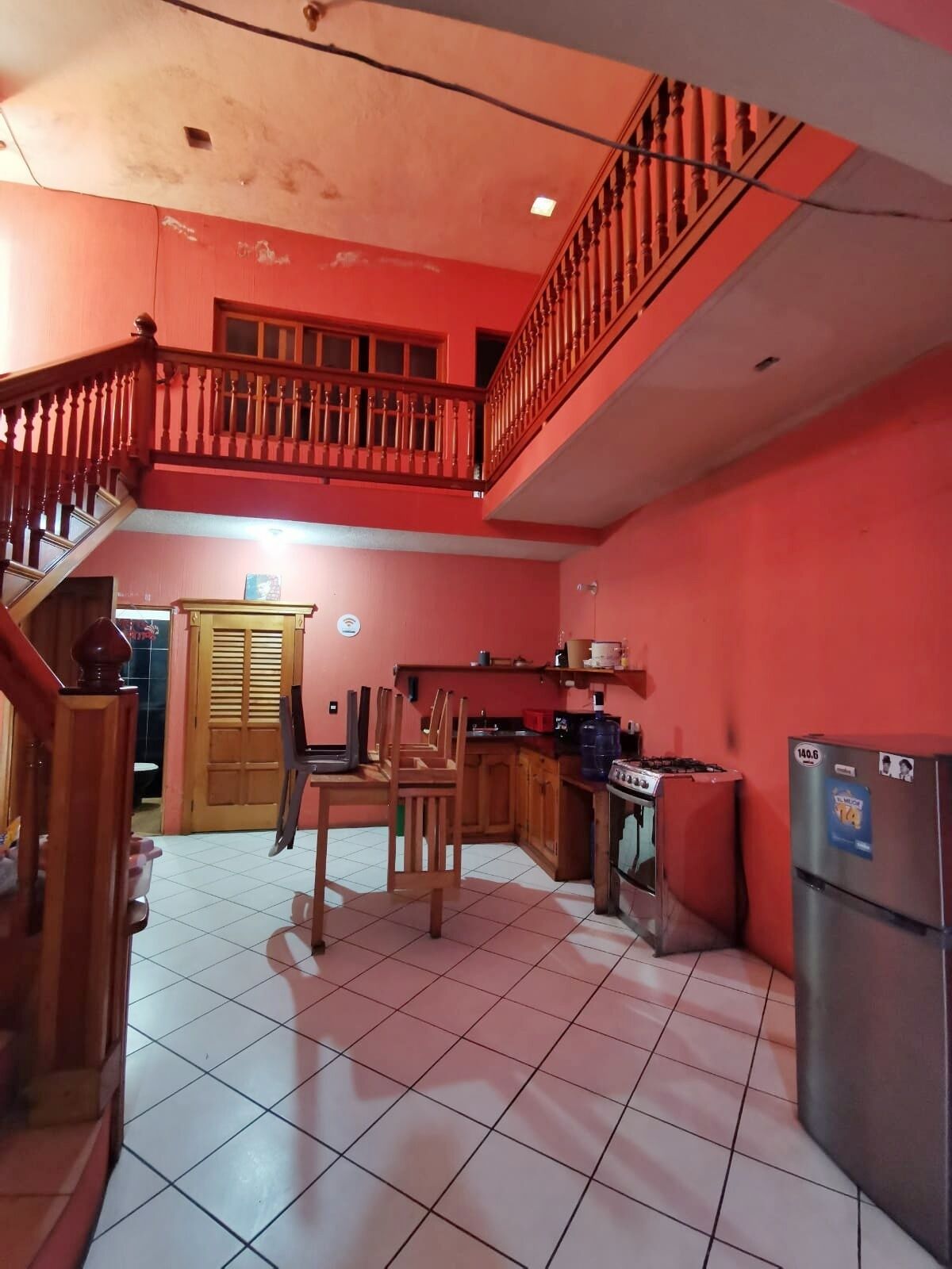 Una cocina con comedor, una escalera y un balcón.