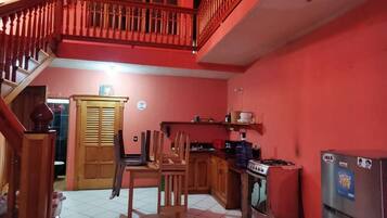 Una cocina con comedor, una escalera y un balcón.