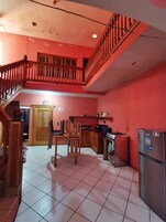 Una cocina con comedor, una escalera y un balcón.