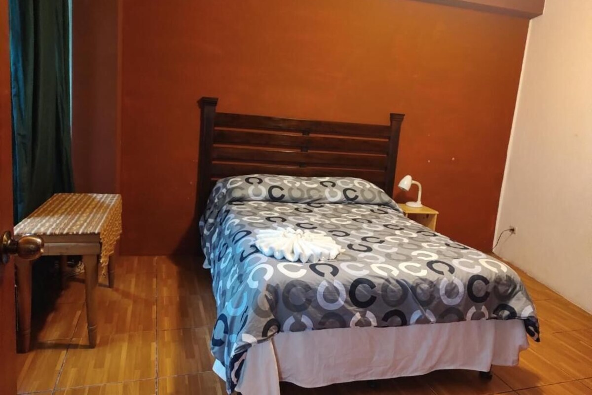 Ein Schlafzimmer mit einem hölzernen Bett, einem Nachttisch und einer Lampe.