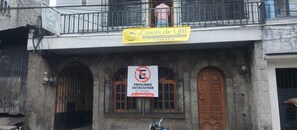 A building with a sign for 'Casas de Qlii' indicating overnight stays. There is a no parking sign and a call to action to call PMT.