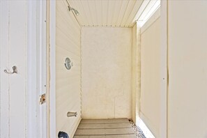 A narrow hallway with a door on the left and a shower area on the right. - Wildwood 4BR w/ Pool | Steps to Beach & Boardwalk (North Wildwood)