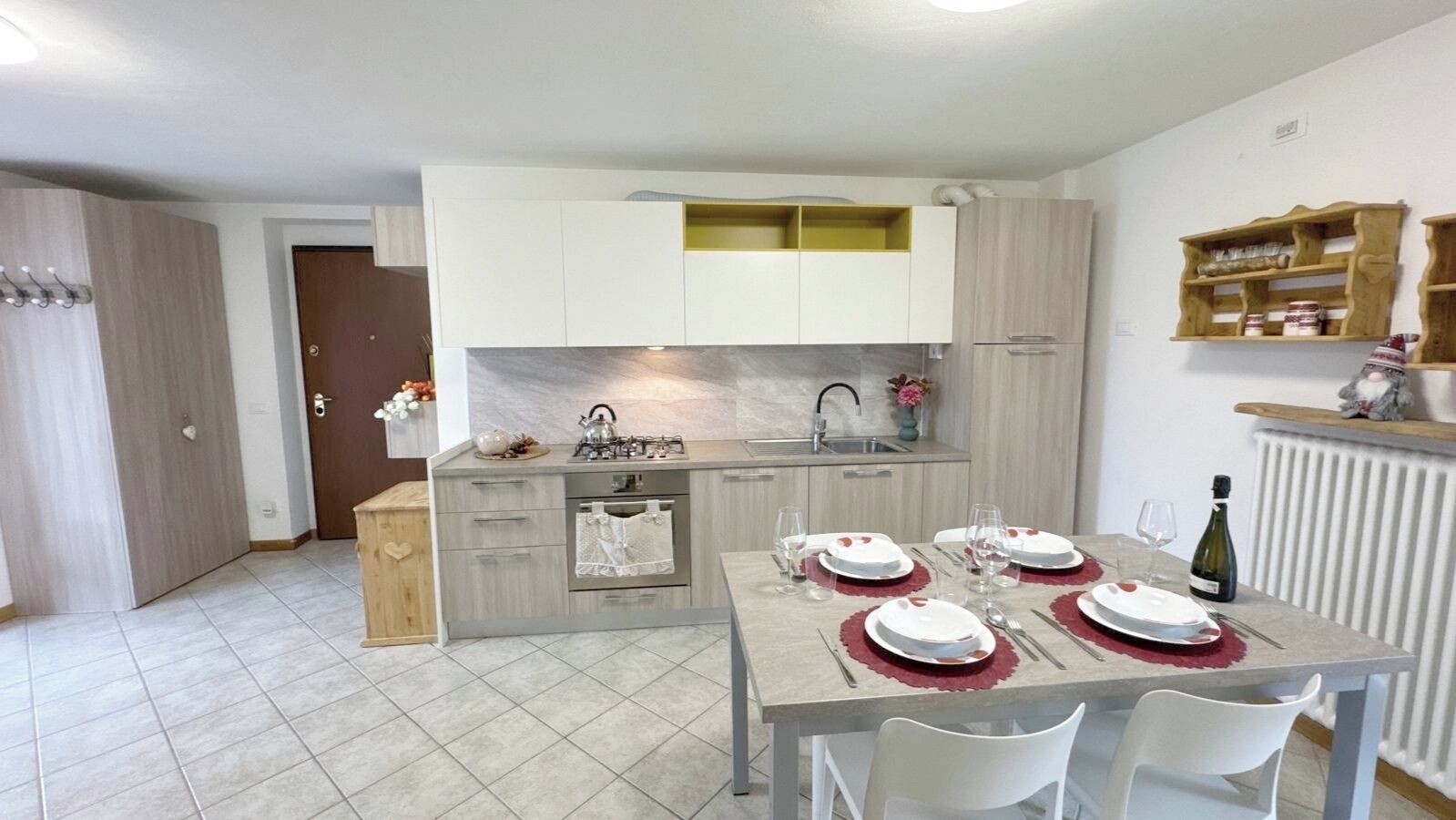 Une cuisine moderne équipée d’une table à manger pour quatre personnes, d’un four encastré et d’un évier.