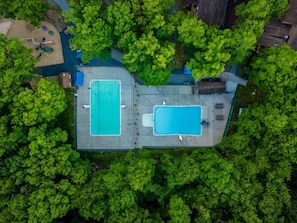 An aerial view of a property with two swimming pools, surrounded by dense greenery. - 4BR-Cozy Cabin | Hot Tub, Fire Pit & Game Room (East Stroudsburg)