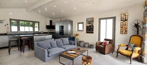 A modern living room with a grey sofa, a wooden coffee table, and a brown armchair. - ODELINE maison spacieuse et lumineuse au calme (Le Bois-Plage-en-Ré)