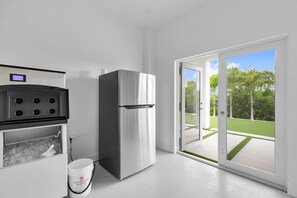 A kitchen with a stainless steel refrigerator, a stove, and a bucket labeled 'Clearwater Marine.' - New Luxury Key Colony Beach 5BR | Pool + 40' Dock (Key Colony Beach)