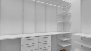 A white closet with multiple shelves and drawers. - New Luxury Key Colony Beach 5BR | Pool + 40' Dock (Key Colony Beach)